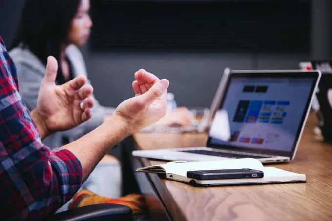 laptop and person raising their hands